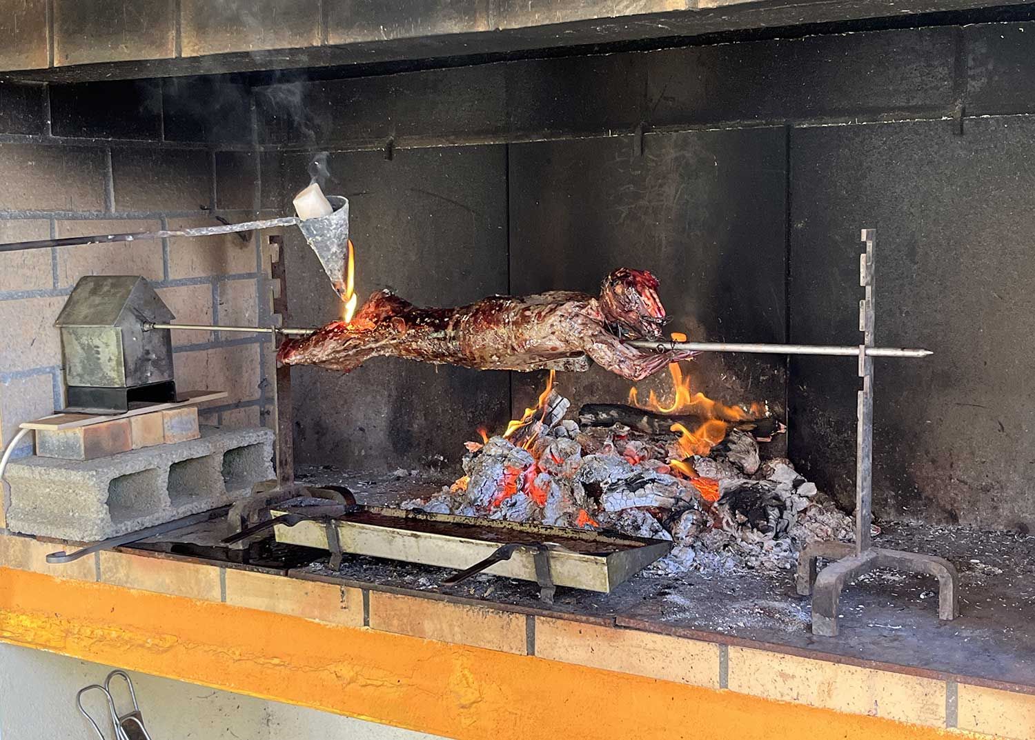 Cuisson d'un lièvre à la broche à l'aide d'un feu de bois et d'un flambadou